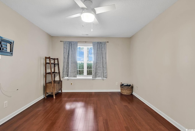 empty room featuring visible vents, wood finished floors, baseboards, ceiling fan, and a textured ceiling