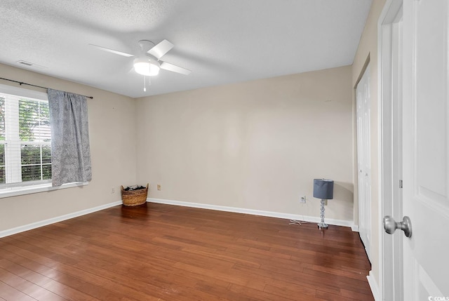 spare room with a ceiling fan, baseboards, visible vents, and wood finished floors