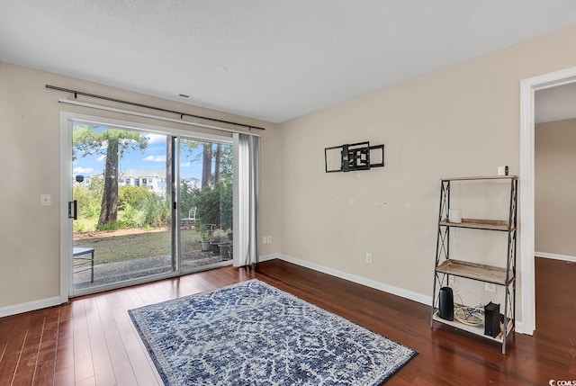 sitting room with a textured ceiling and dark hardwood / wood-style floors