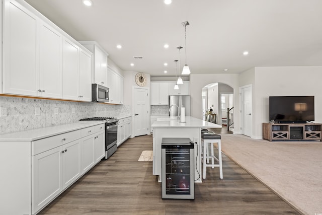 kitchen with white cabinetry, a kitchen island with sink, and appliances with stainless steel finishes