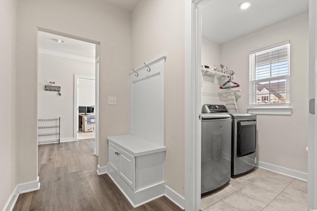 clothes washing area with light hardwood / wood-style floors and separate washer and dryer