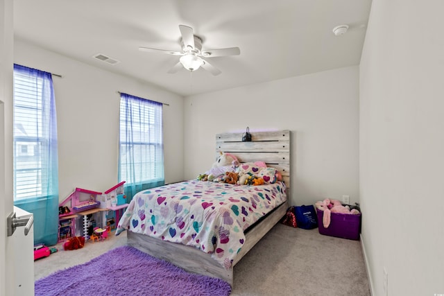 carpeted bedroom with multiple windows and ceiling fan