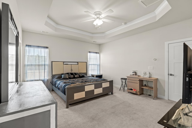 bedroom featuring light carpet, ceiling fan, and a tray ceiling