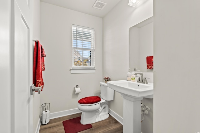 bathroom featuring wood-type flooring and toilet