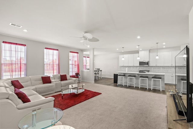 living room with dark hardwood / wood-style floors and ceiling fan