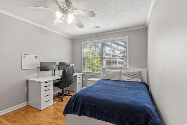 bedroom featuring a textured ceiling, light wood-type flooring, ceiling fan, and ornamental molding