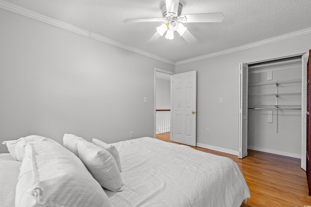 bedroom featuring ceiling fan, a closet, crown molding, and hardwood / wood-style flooring