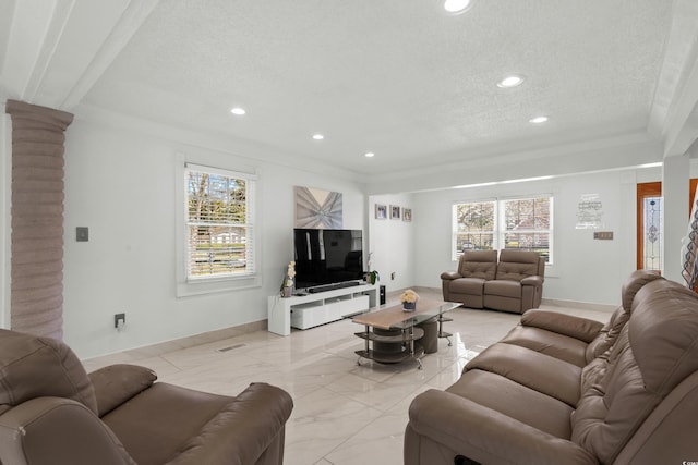 living room with a healthy amount of sunlight, ornamental molding, and a textured ceiling