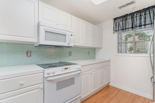 kitchen with backsplash, light wood-type flooring, white appliances, and white cabinets