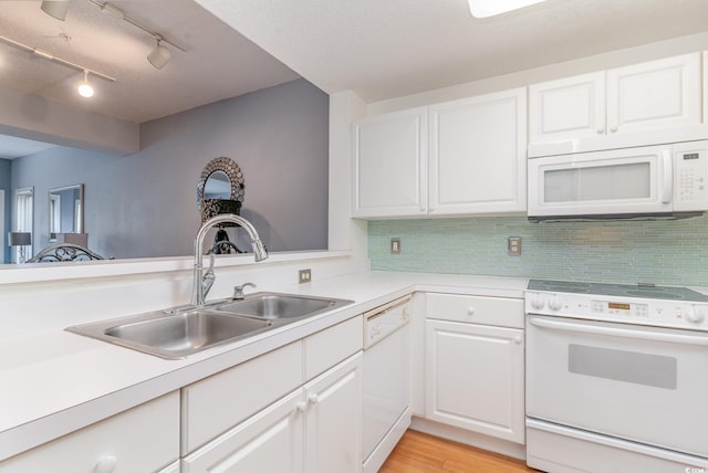 kitchen featuring light hardwood / wood-style flooring, white appliances, white cabinetry, sink, and kitchen peninsula