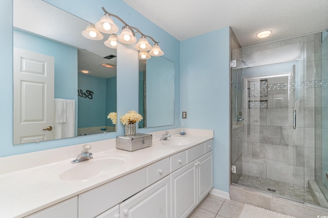 bathroom featuring tile patterned floors, an enclosed shower, a textured ceiling, and vanity