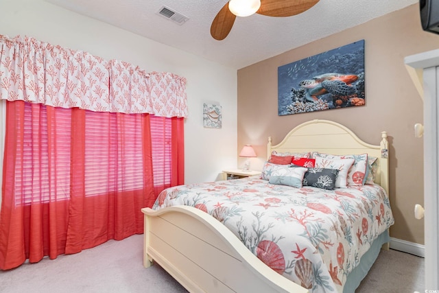 bedroom featuring ceiling fan, carpet floors, and a textured ceiling