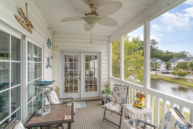 sunroom / solarium with a water view, ceiling fan, and wooden ceiling