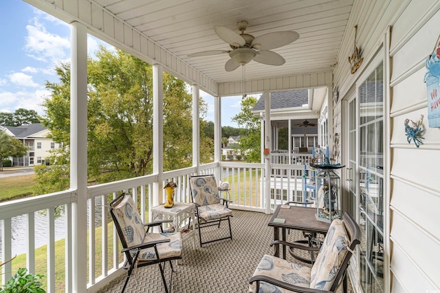 sunroom with ceiling fan, wood ceiling, a water view, and a wealth of natural light