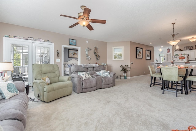 carpeted living room with ceiling fan and a textured ceiling