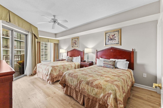 bedroom with light wood-type flooring, ceiling fan, and a textured ceiling