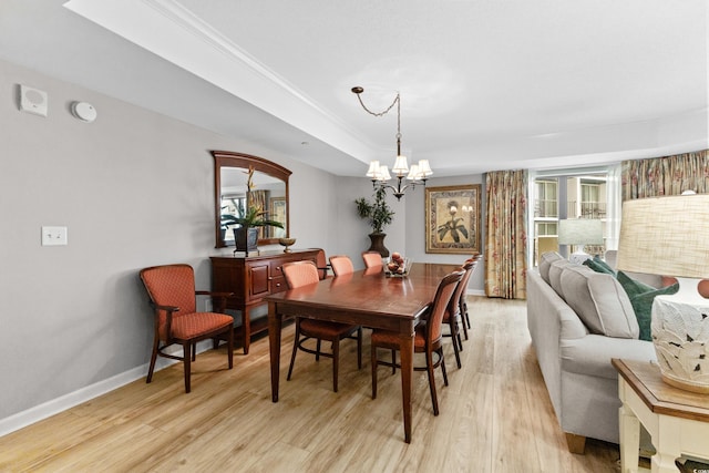 dining room with crown molding, light hardwood / wood-style floors, and a chandelier