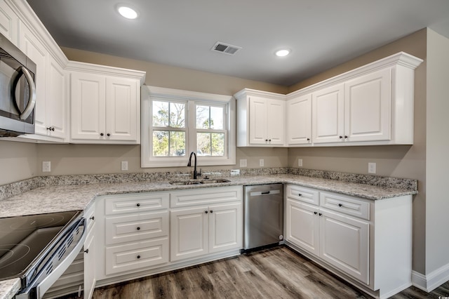 kitchen featuring wood-type flooring, sink, white cabinetry, and stainless steel appliances