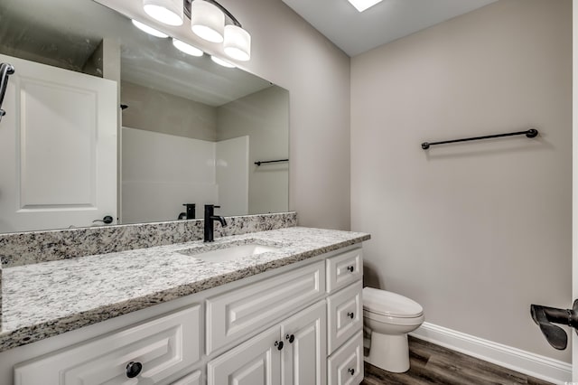 bathroom featuring toilet, walk in shower, hardwood / wood-style flooring, and vanity