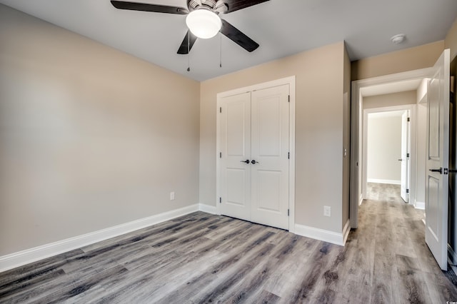 unfurnished bedroom featuring ceiling fan, a closet, and light hardwood / wood-style floors