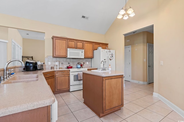 kitchen with white appliances, pendant lighting, a notable chandelier, sink, and lofted ceiling