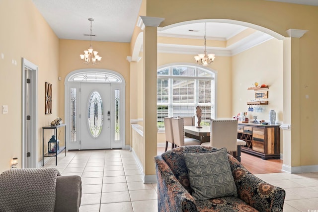 entrance foyer with a healthy amount of sunlight, light tile patterned floors, and a chandelier