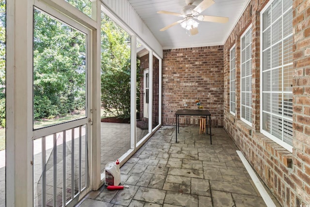 unfurnished sunroom featuring a wealth of natural light and ceiling fan