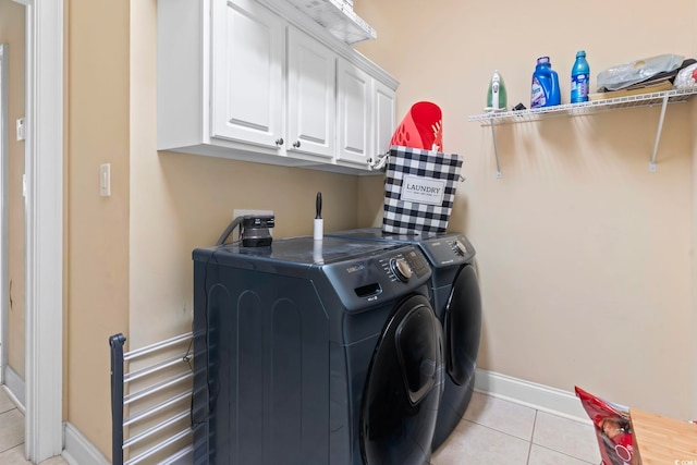 laundry room featuring cabinets, washer and clothes dryer, and light tile patterned floors