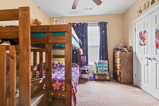 bedroom featuring a closet, ceiling fan, a textured ceiling, and carpet floors