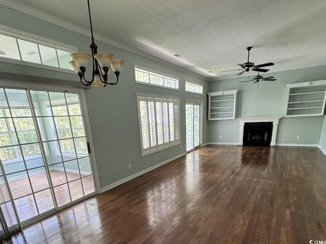 unfurnished living room with a healthy amount of sunlight, ceiling fan with notable chandelier, and dark wood-type flooring