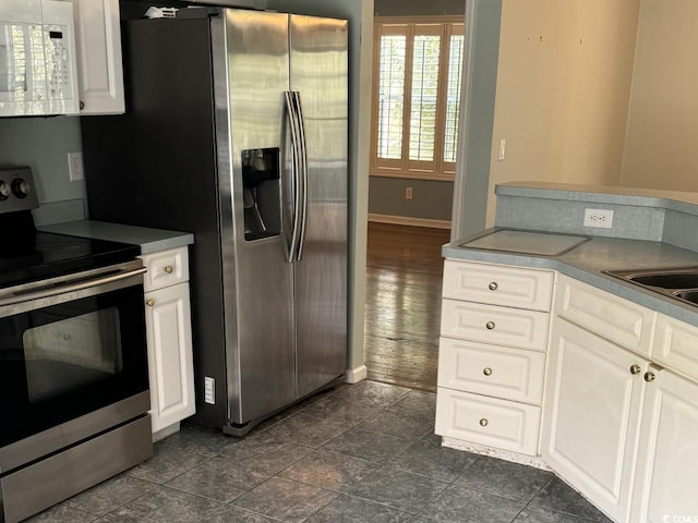 kitchen with white cabinets, stainless steel appliances, and dark hardwood / wood-style floors