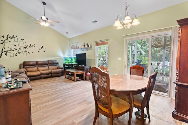 dining area featuring ceiling fan with notable chandelier, vaulted ceiling, and light hardwood / wood-style flooring