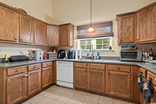 kitchen with pendant lighting, white dishwasher, light tile patterned flooring, and sink