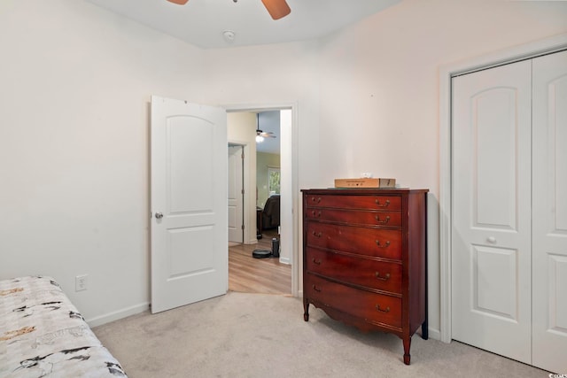 bedroom featuring ceiling fan, a closet, and light carpet