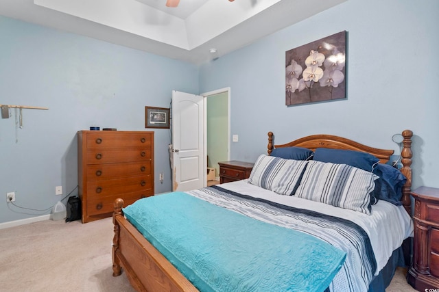 carpeted bedroom featuring a raised ceiling and ceiling fan