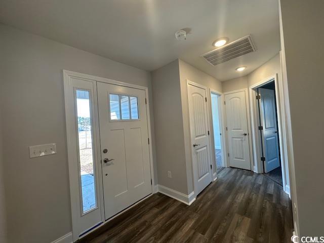 entryway with dark wood-style flooring, visible vents, and baseboards