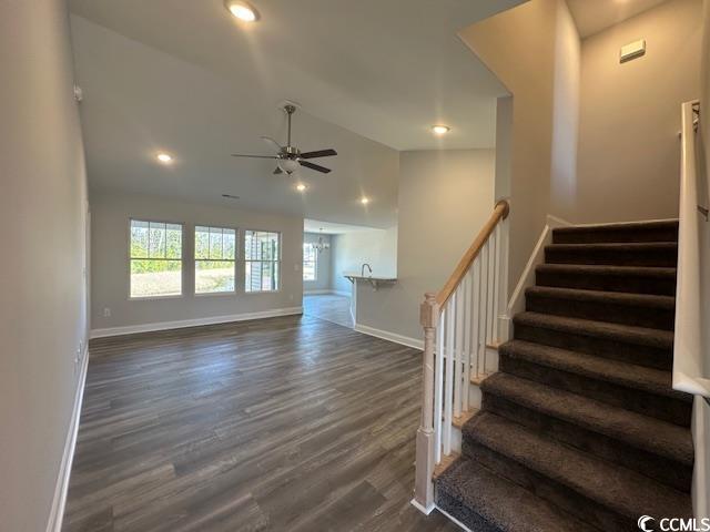 interior space featuring recessed lighting, a ceiling fan, vaulted ceiling, wood finished floors, and baseboards