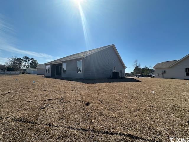 view of property exterior with central AC and a yard