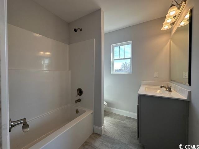 full bathroom featuring baseboards, shower / bath combination, vanity, and toilet