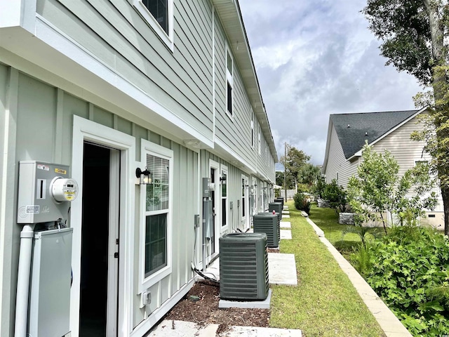 6306 Somerset Dr, Myrtle Beach, SC 29572 - view of property exterior with board and batten siding, a lawn, and central air condition unit