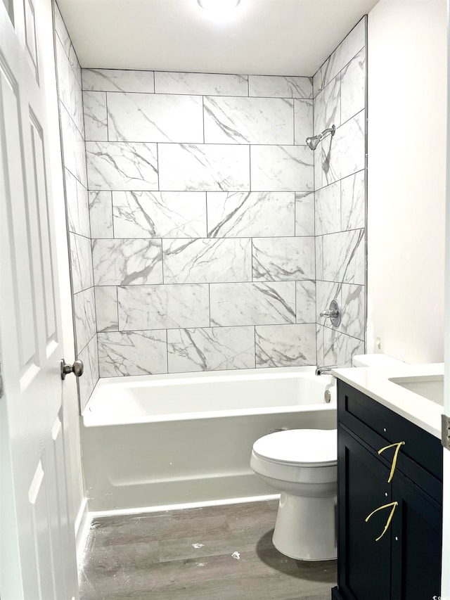 full bathroom featuring tiled shower / bath combo, vanity, toilet, and hardwood / wood-style floors