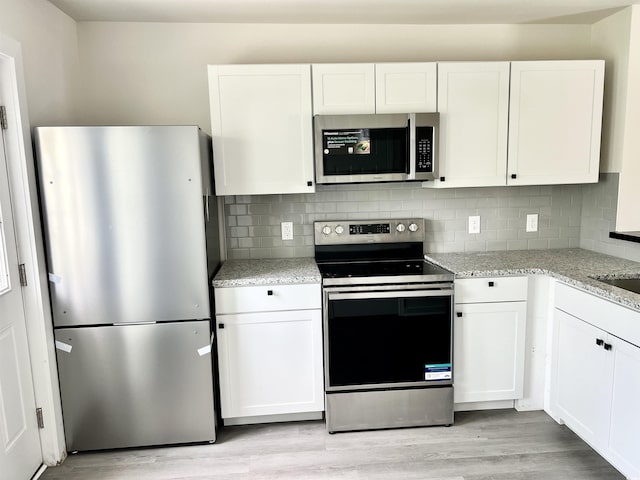6306 Somerset Dr, Myrtle Beach, SC 29572 - kitchen featuring light wood-style flooring, appliances with stainless steel finishes, and white cabinets