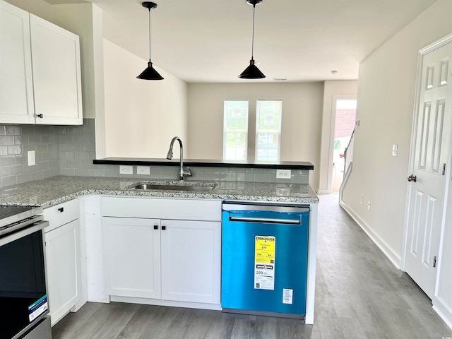 kitchen featuring appliances with stainless steel finishes, white cabinets, light hardwood / wood-style flooring, decorative light fixtures, and sink