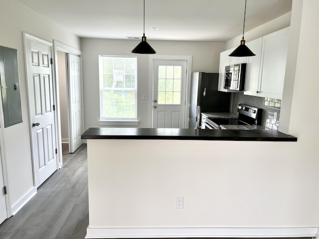6306 Somerset Dr, Myrtle Beach, SC 29572 - kitchen with a peninsula, dark countertops, white cabinets, and stainless steel appliances