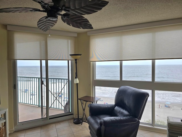 sitting room with plenty of natural light, a water view, and light tile patterned flooring