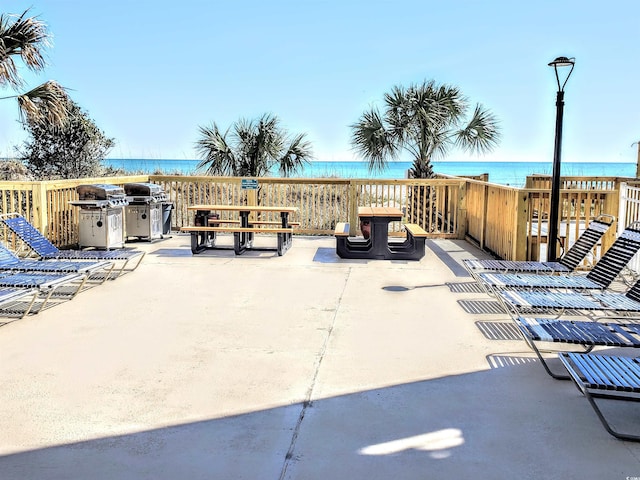 view of patio / terrace with area for grilling and a water view