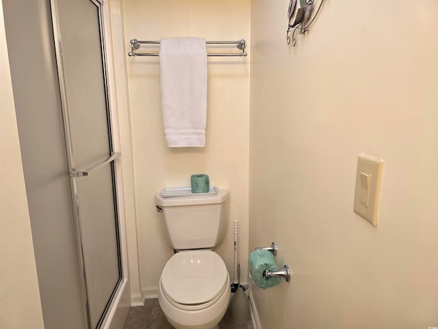 bathroom with toilet, walk in shower, and tile patterned flooring