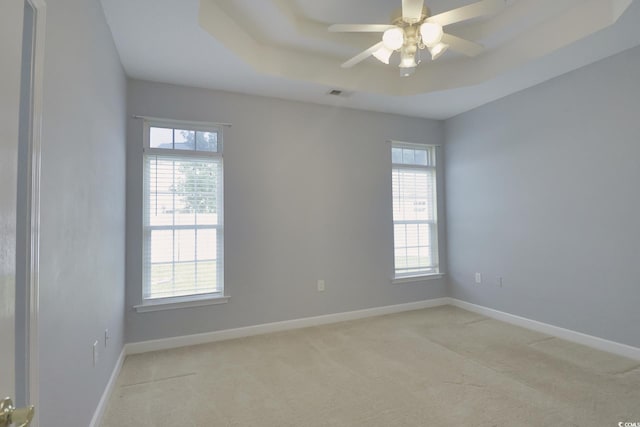 carpeted empty room with ceiling fan and a wealth of natural light