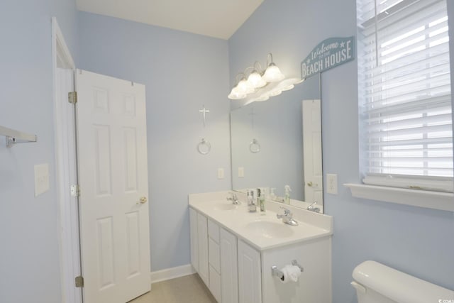 bathroom featuring toilet, plenty of natural light, and vanity