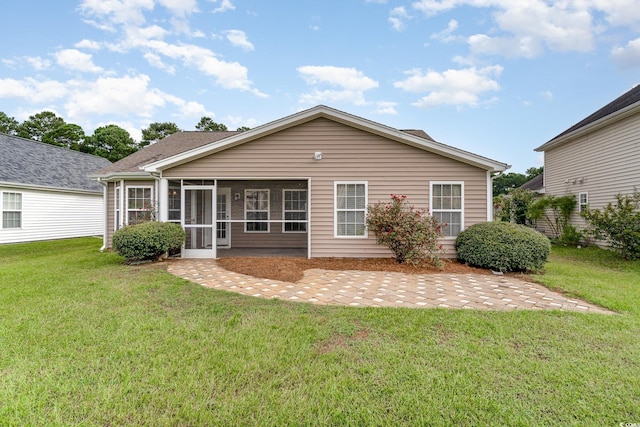 rear view of property featuring a sunroom, a yard, and a patio